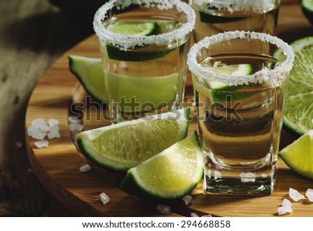 Gold Mexican tequila with lime and salt, selective focus