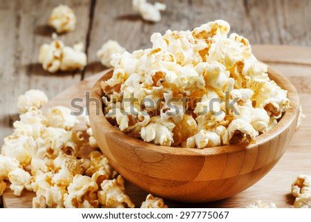 Sweet caramel popcorn in a wooden bowl, selective focus