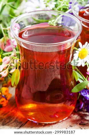 Black tea with  herbs in an authentic Middle Eastern glasses on an old wooden table, selective focus