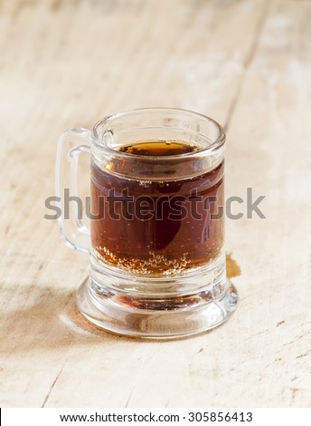 light beer in a little old-fashioned mug on old wooden table, selective focus