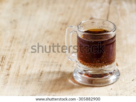 light beer in a little old-fashioned mug on old wooden table, selective focus
