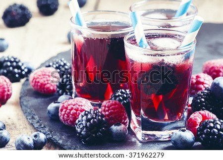 Ice berry tea with raspberries, blackberries and blueberries, selective focus