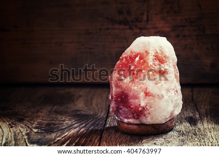 Salt lamps of pink Himalayan salt, vintage wooden background, selective focus