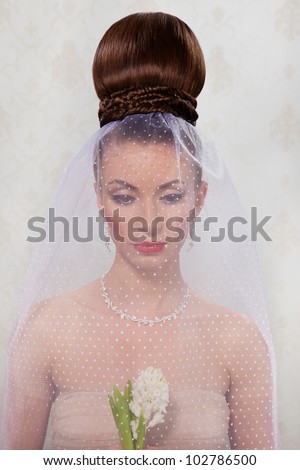 Attractive young bride with wedding hair decorating with a plaits and veil