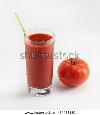 Glass with fresh tomato juice near the tomato