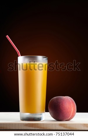 Fresh peach juice in glass on dark background