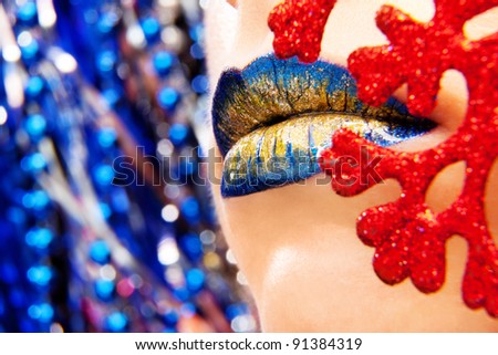 Glamour Blue Gold gloss lips moving up on bright blue background, shallow focus