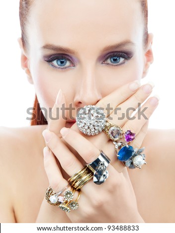 Attractive young woman with diamonds on the hands looking to the camera on the white background