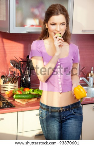 Attractive young woman eating health food smiling and joyful in the modern kitchen