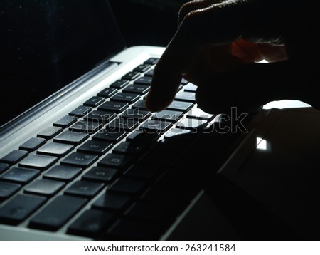 Cybercrime - one Hand on Keyboard in the dark