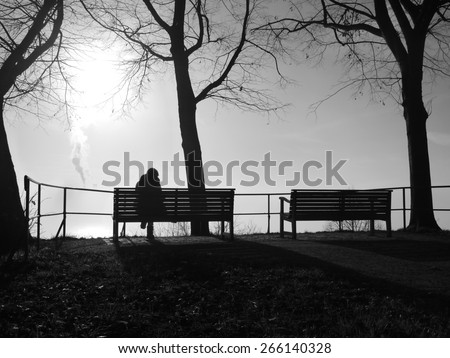 depressed woman sitting alone on a park bench