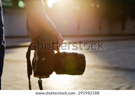 photographer holding a camera in the city with night-lighting