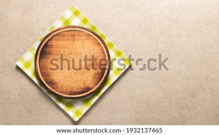 Pizza cutting board and cloth napkin on stone surface of table. Food recipe concept at tabletop or wall background texture with copy space. Flat lay  top view