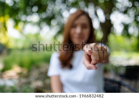 Closeup image of a woman pointing finger at you