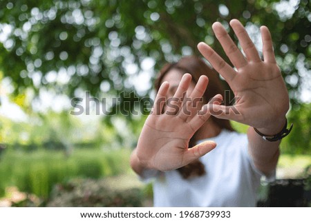 A woman outstretched hand and showing stop hand sign