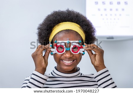African young woman girl doing eye test checking examination using trial frame in clinic or optical shop. Eyecare concept.