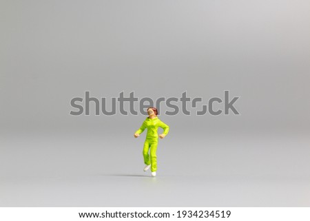 Miniature people Running on gray background and free space for text
