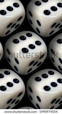 A vertical shot of white dice on a black surface under the lights