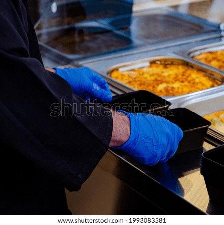 Chef\'s hands organizing containers for food in the restaurant