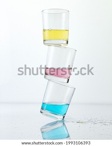A stack of colorful cocktail drinks isolated on white background