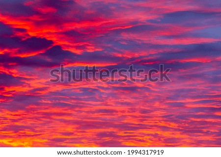 A gorgeous sky during a magical sunset with reddish-pink highlights on gentle purple clouds