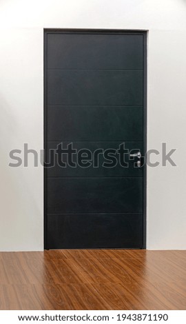 Closed Black Door in Room With Laminate Floor
