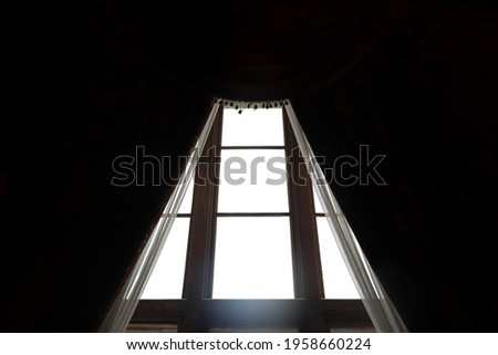 Fragment of window with curtains in old mansion