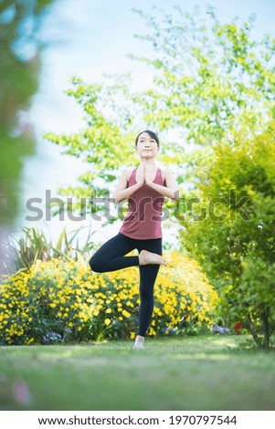 Young woman doing yoga in a green park