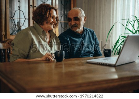 Senior couple drinking coffee at home while having a romantic moment together