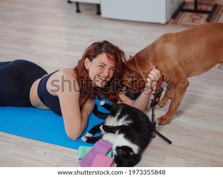 Online Training. Fit Young Woman Excersising At Home, with her pets. Self-isolation is beneficial, entertainment and education on the Internet. Healthy lifestyle concept.