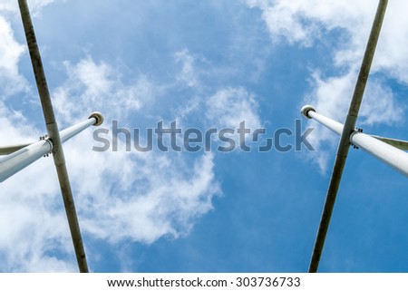 Flagpoles flagstaffs. Minimal art and design. Urban geometry. Blue sky background. Cloudy blue sky background. Modern photography. Abstract art and design.