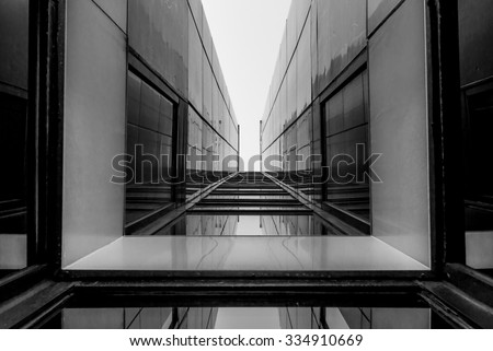 Urban Geometry, looking up to glass building. Modern architecture, glass and steel. Abstract architectural design. Inspirational, artistic image. Industrial design. .Modern building. Black and white.