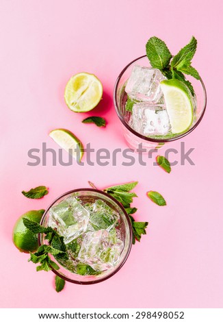 two cocktail shots from birds eye view with mint leaves, lime and ice