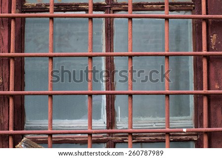 Painted iron bars on the window of an abandoned building
