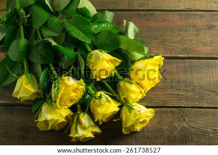 Yellow roses on a wooden background