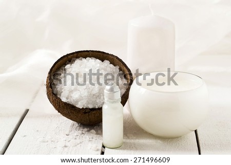 Coconut SPA program: sea salt with an extract of coconut, coconut oil, foam, scented candle on a white background. Selective focus