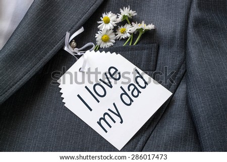 Congratulations to the dad in his pocket jacket. Daisies and a card with the words: I love my dad