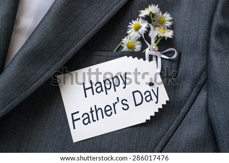 The idea congratulations father on the holiday - a card that read: Happy father\'s day and daisies in the pocket of his jacket