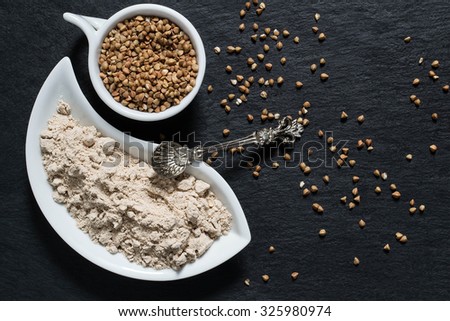 Source vitamin E and group B, calcium, phosphorus, zinc, manganese and copper - buckwheat groats and flour on the surface of the slate