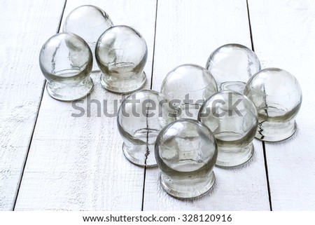 Old medical cupping glass on a white wooden table. They are used to relax the muscles and treat inflammation