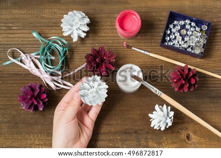 Making Christmas decorations from pine cones. Children project, step by step photo instructions. Step 3. Child painted pine cones in white and burgundy color