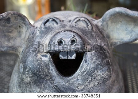 A ceramic pig pottery in the colors of nature, grey and brown