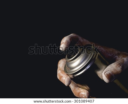Spray can in hand isolated on black background