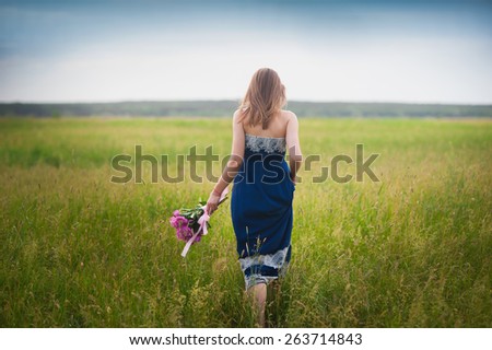 Young beautiful girl with a bouquet of peonies is in the field,concept