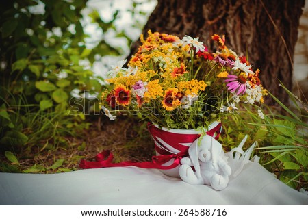 Bouquet of wild flowers with a child\'s toy rabbit, concept, lifestyle