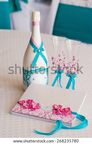 Wedding bottle of drink, wedding glasses and a beautiful book for wishes