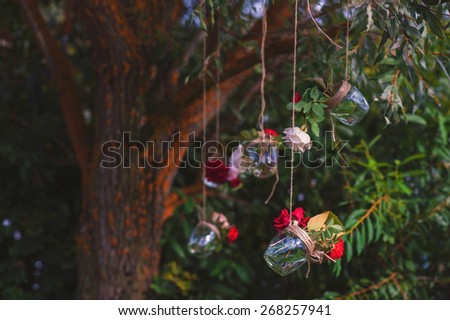 Decorative glass jars hanging on the tree with bright flowers, decor, decorating, decoration
