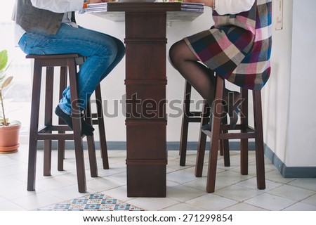 Stylish young couple sitting on high chairs at the table, lifestyle-concept