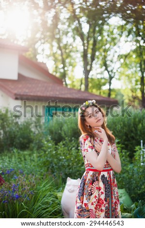 Portrait of a beautiful young woman in a bright dress on a head a wreath of flowers, lifestyle, youth