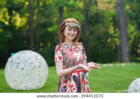 Beautiful young woman in a wreath of flowers smiling portrait on nature, the joy of life, smile